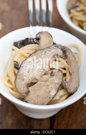 Italiano gli spaghetti e i funghi selvatici freschi sulla tavola in legno rustico Foto Stock