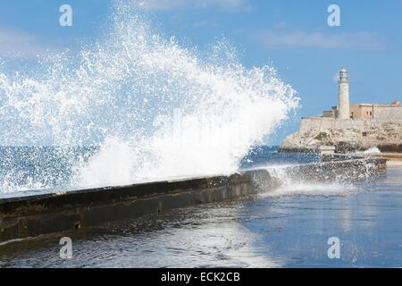 Cuba, La Habana, onda oltre il Malecon e Castillo de los Tres Reyes Magos del Moro in background Foto Stock