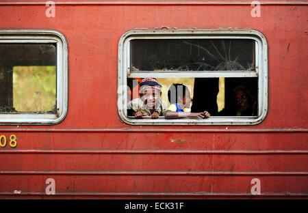 Sri Lanka, Ella, locale famiglia con bambini guardando attraverso la finestrella del treno Foto Stock