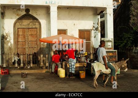 Il Kenya, l'arcipelago di Lamu, Lamu uomo su donkey shopping presso il mare locale mercato anteriore Foto Stock