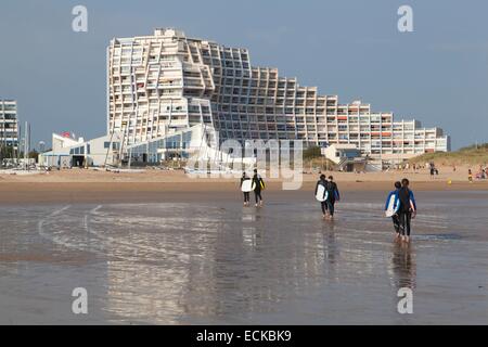 Francia, Vendee, Saint Jean de Monts, surfisti di camminare sulla spiaggia e il lungomare di edifici