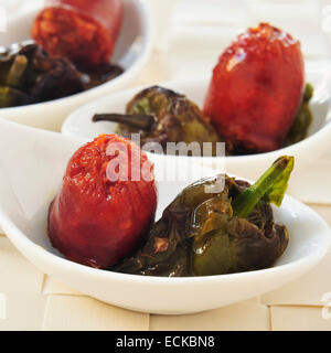 Alcune piccole ciotole con lo spagnolo frittura di chorizo e peperoni Padron servita come tapas Foto Stock