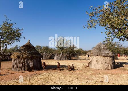 La Namibia, regione di Kunene, Kaokoland, villaggio Himba nei pressi di Kamanjab, Himba bambini davanti a una capanna Foto Stock