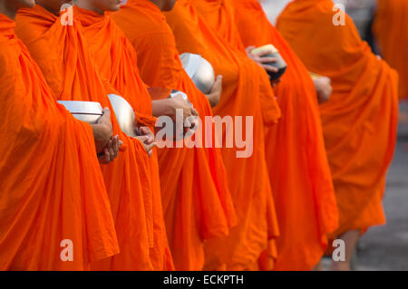 La linea di monaci holding di accattonaggio tradizionali bocce durante la mattinata alms dando, Wat Benchamabophit (Tempio in marmo), Bangkok, Thailandia Foto Stock