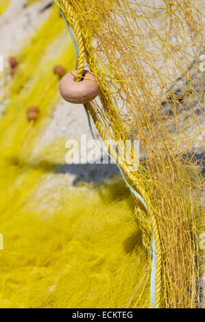 Close up del galleggiante su giallo reti da pesca sulla spiaggia Foto Stock