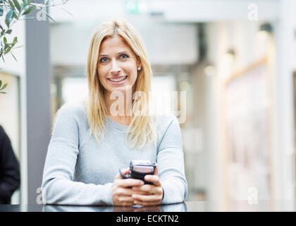 Ritratto di felice metà donna adulta nel centro commerciale per lo shopping Foto Stock