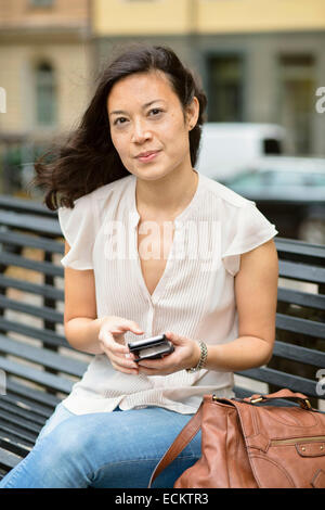 Ritratto di donna con un cellulare in città Foto Stock