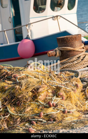 Le reti da pesca impilati sul molo Foto Stock