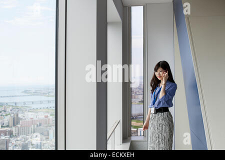 Una donna lavoratrice in un edificio per uffici. Foto Stock