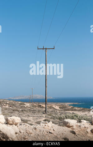 Tralicci in legno di una linea di alimentazione sulla costa del mare Foto Stock