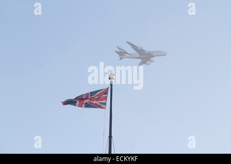 Westminster, Londra, Regno Unito. Xvi Dec, 2014. Un Emirates aereo commerciale vola sopra le case del Parlamento con l'Unione Jack Credito: amer ghazzal/Alamy Live News Foto Stock