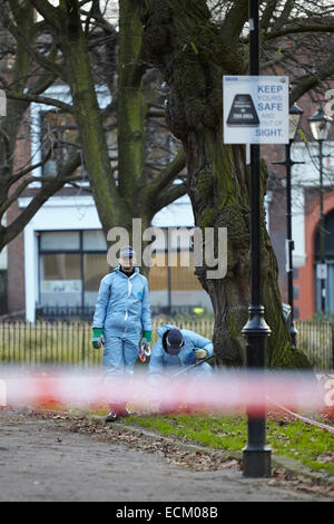 Londra, Regno Unito. Xvi Dec, 2014. Un uomo è stato ucciso nella gamba la scorsa notte (15 dicembre 2014) a circa 23.30 vicino a campi di Highbury park, a seguito di una perturbazione presso il Garage music venue. Scena del crimine gli investigatori (in blu) sono illustrati oggi, ricerca la zona con un rivelatore di metalli. Gli ufficiali di polizia di guardia intorno alla scena del crimine. L'uomo di lesioni non sono pensati per essere un pericolo per la vita. Islington. Londra. Regno Unito. Dicembre 16th, 2014. Credito: Sam Barnes/Alamy Live News Foto Stock