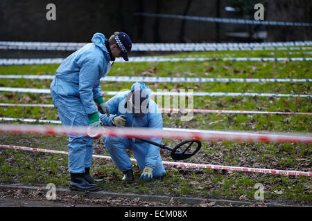 Londra, Regno Unito. Xvi Dec, 2014. Un uomo è stato ucciso nella gamba la scorsa notte (15 dicembre 2014) a circa 23.30 vicino a campi di Highbury park, a seguito di una perturbazione presso il Garage music venue. Scena del crimine gli investigatori (in blu) sono illustrati oggi, ricerca la zona con un rivelatore di metalli. Gli ufficiali di polizia di guardia intorno alla scena del crimine. L'uomo di lesioni non sono pensati per essere un pericolo per la vita. Islington. Londra. Regno Unito. Dicembre 16th, 2014. Credito: Sam Barnes/Alamy Live News Foto Stock