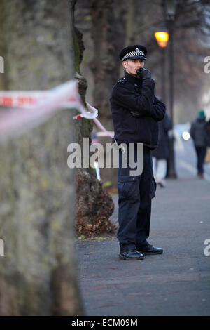 Londra, Regno Unito. Xvi Dec, 2014. Un uomo è stato ucciso nella gamba la scorsa notte (15 dicembre 2014) a circa 23.30 vicino a campi di Highbury park, a seguito di una perturbazione presso il Garage music venue. Scena del crimine gli investigatori (in blu) sono illustrati oggi, ricerca la zona con un rivelatore di metalli. Gli ufficiali di polizia di guardia intorno alla scena del crimine. L'uomo di lesioni non sono pensati per essere un pericolo per la vita. Islington. Londra. Regno Unito. Dicembre 16th, 2014. Credito: Sam Barnes/Alamy Live News Foto Stock