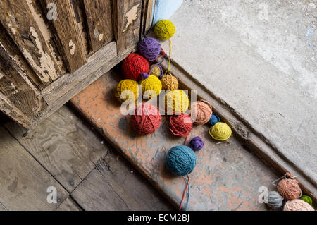 Palle di lana colorata alla porta di una vecchia porta Foto Stock