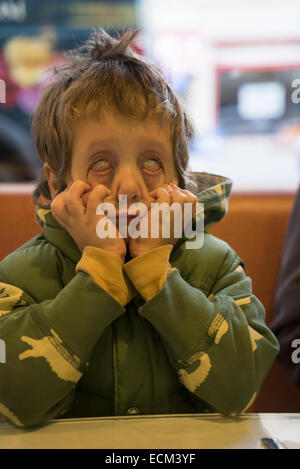 Quattro anni di vecchio ragazzo fa una faccia paura. Foto Stock