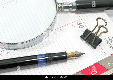 Penna stilografica e lente di ingrandimento sul personal organizer Foto Stock