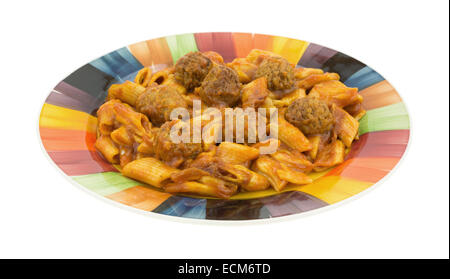 Una porzione di penne pasta con le polpette di carne in salsa di pomodoro su una piastra colorati. Foto Stock