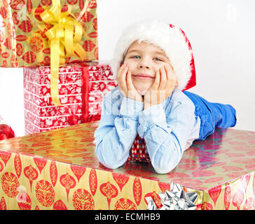 Affascinante piccolo ragazzo disteso sul regalo di Natale Foto Stock