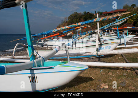 Una barca poggia sulla sabbiosa spiaggia di Amed, un villaggio di pescatori nella parte Est di Bali. Amed è una lunga striscia costiera di villaggi di pescatori in E Foto Stock