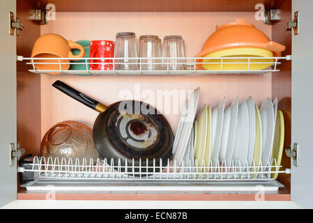 Piatti di essiccazione, pan, tazze e bicchieri nel cestello portastoviglie Foto Stock