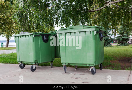Verde contenitori di riciclaggio sulla strada della città Foto Stock