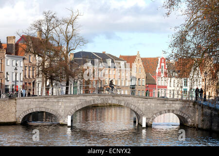 Un uomo in bicicletta su un ponte sul canale in inverno, Bruges, Belgio, Europa Foto Stock