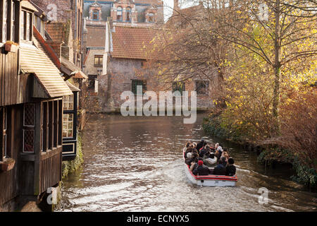 Una barca piena di turisti in un tour dei canali in autunno, canale di Bruges, Belgio, Europa Foto Stock