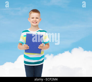 Poco sorridente studente Ragazzo con libro blu Foto Stock