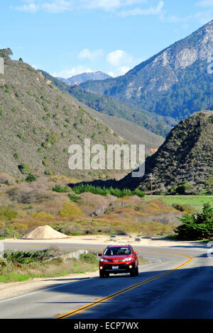 Auto rossa viaggia sull'autostrada 1 in Big Sur area della contea di Monterey in California Foto Stock