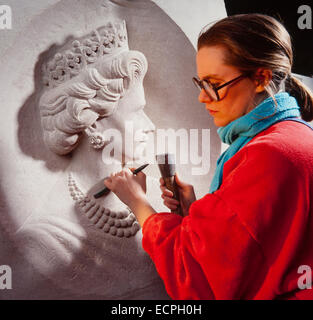 Stone Mason carving un ritratto della regina Elisabetta 2 in un blocco di calcare. Foto Stock