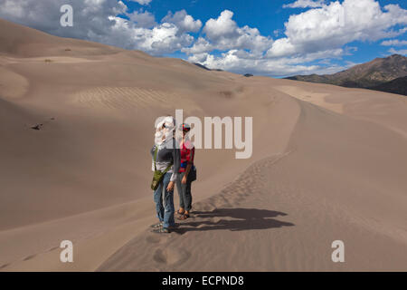 Visitatori escursione in grandi dune di sabbia del Parco Nazionale che contiene le più grandi dune di sabbia in America del Nord - COLORADO MR Foto Stock