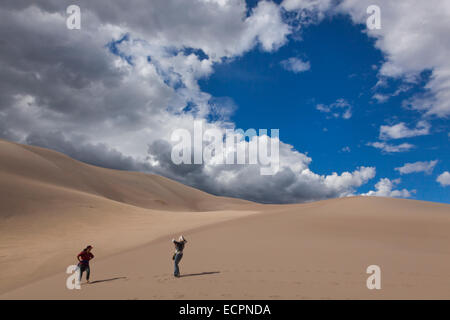 Visitatori escursione in grandi dune di sabbia del Parco Nazionale che contiene le più grandi dune di sabbia in America del Nord - COLORADO MR Foto Stock