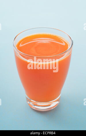 La carota e Apple appena premuto il succo in vetro su uno sfondo chiaro. Un sano materie prime vegetali e frutta bevanda per la sana prima colazione Foto Stock