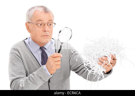 Senior esaminando un mazzetto di carta tagliuzzata isolati su sfondo bianco Foto Stock