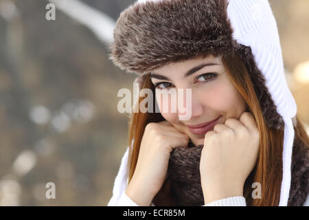 La bellezza della donna faccia calorosamente ritratto vestita in inverno tenendo una sciarpa all'aperto Foto Stock