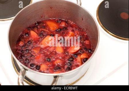 Una pentola bollente frutto di essere ridotta in preparazione per la realizzazione di marmellate e torte di alcuni e sminuzzare ripieni Foto Stock