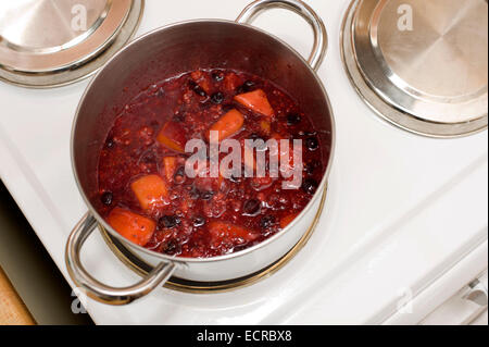 Una pentola bollente frutto di essere ridotta in preparazione per la realizzazione di marmellate e torte di alcuni e sminuzzare ripieni Foto Stock