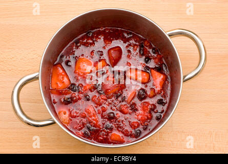 Una pentola bollente frutto di essere ridotta in preparazione per la realizzazione di marmellate e torte di alcuni e sminuzzare ripieni Foto Stock