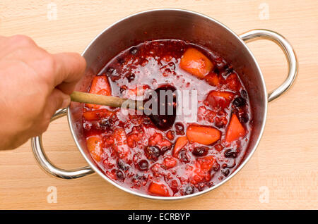 Una pentola bollente frutto di essere ridotta in preparazione per la realizzazione di marmellate e torte di alcuni e sminuzzare ripieni Foto Stock