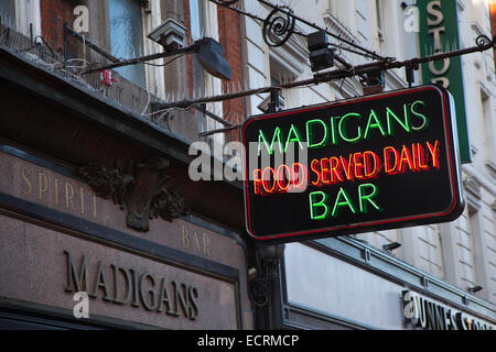 Irlanda, Dublino, insegna al neon fuori Madigans bar in Earl Street. Foto Stock