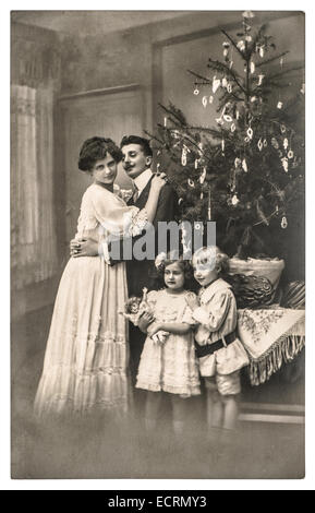 Famiglia vittoriana con genitori e bambini con albero di natale . vintage foto con pellicola originale del grano e la sfocatura Foto Stock