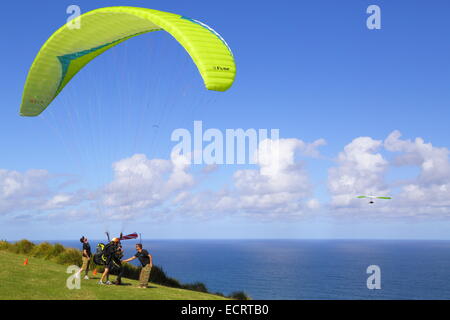 Un parapendio in tandem si prepara a sollevare oltre l'Oceano Pacifico a Bald Hill, Nuovo Galles del Sud, Australia. Foto Stock