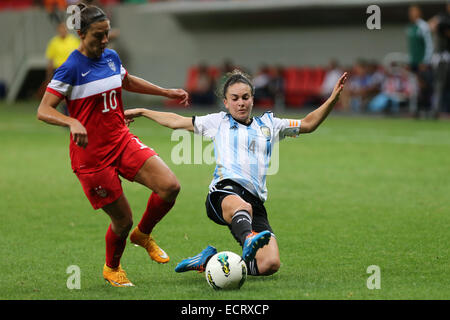 Brasilia, Brasile. Xviii Dicembre, 2014. Argentina Agustina Barroso (R) il sistema VIES con lettore DEGLI STATI UNITI Carli Lloyd durante il loro match di 2014 Torneo Internazionale di Brasilia in Brasilia, capitale del Brasile, Dic 18, 2014. Gli Stati Uniti ha vinto 7-0. © Xu Zijian/Xinhua/Alamy Live News Foto Stock