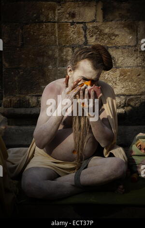 Un Aghori Shaiva ascetica sadhu che copre il volto con la cenere e la vernice al tempio di Pashupatinath che è sul patrimonio mondiale Unesco elenco di Kathmandu in Nepal Foto Stock