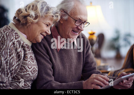 Anziani uomo e donna che utilizza il touchpad Foto Stock