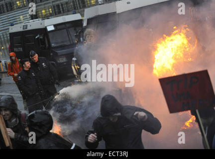 Bruxelles, Belgio. Xix Dec, 2014. La polizia belga stare accanto a un'effigie del Cancelliere tedesco Angela Merkel come manifestanti caseificio bruciare balle di fieno in corrispondenza di un incrocio di fronte al quartier generale dell'UE a Bruxelles, Belgio, durante un movimento di protesta contro la politica di austerità e gli scambi e gli investimenti transatlantici di partenariato (TTIP), Dicembre 19, 2014. Credito: Voi Pingfan/Xinhua/Alamy Live News Foto Stock