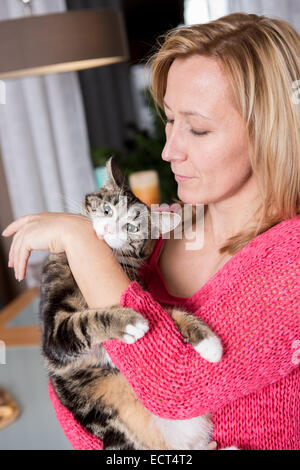 Una donna con un gatto in cucina Foto Stock