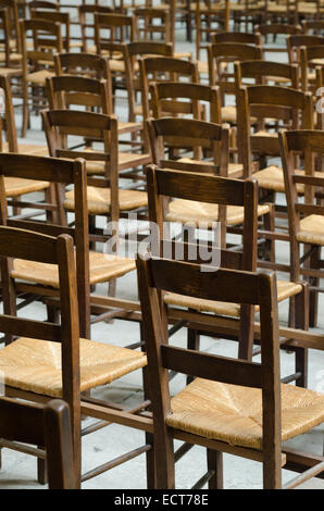 File di sedie usurate in una chiesa di Parigi, Francia Foto Stock
