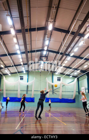 Scuola secondaria educazione fisica Wales UK: ragazze adolescenti a giocare una palla in gioco la palestra Foto Stock